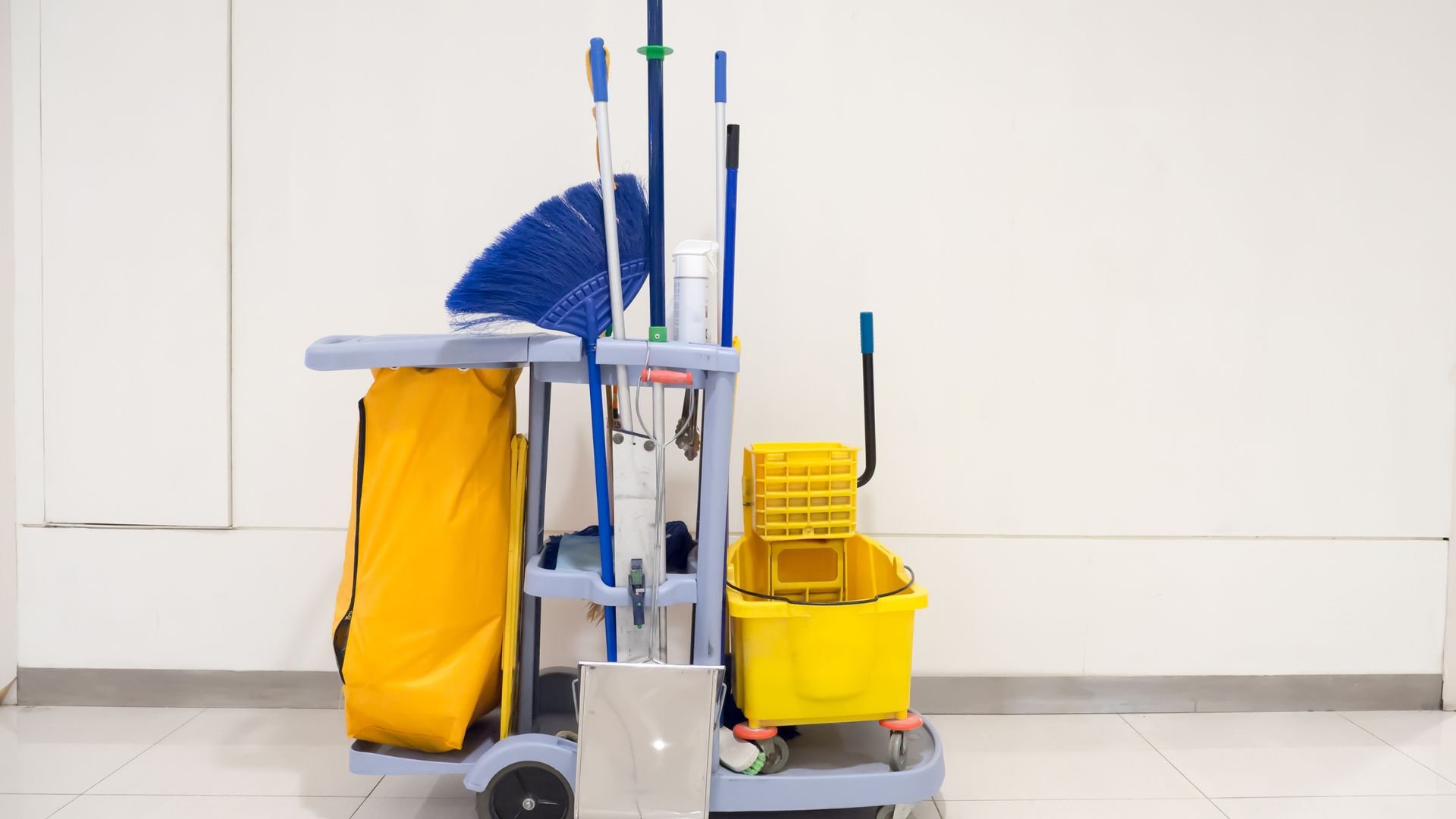 Professional cleaning cart with mop, broom, bucket, and yellow laundry bag